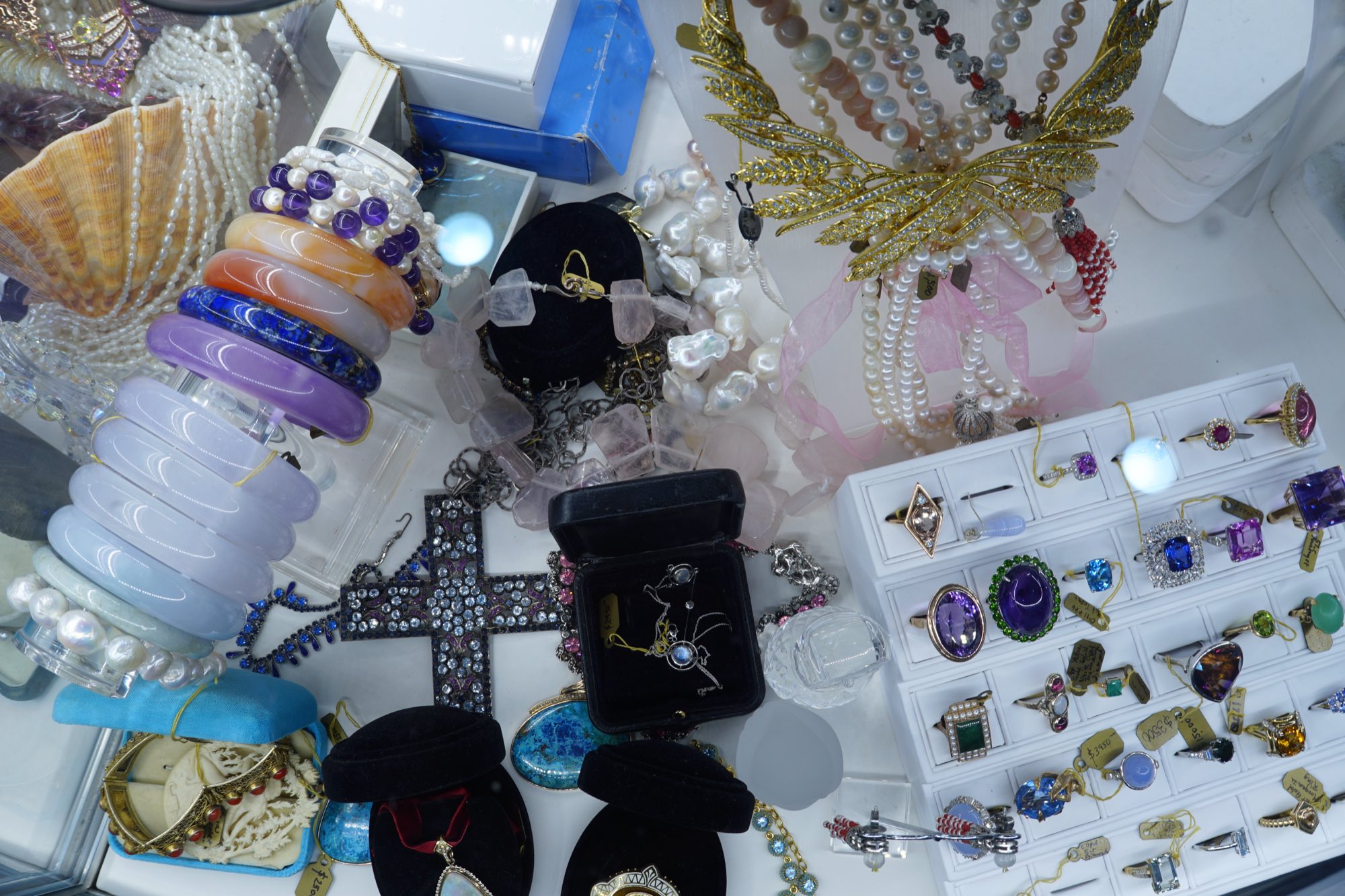Jewellery laid out for cataloguing: bangles, beads, brooches and rings